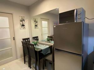 uma sala de jantar com uma mesa e um frigorífico em Lovely 1 bedroom at Vista Shaw Residences em Manila