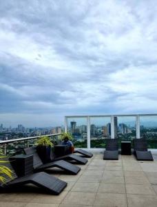 uma varanda com cadeiras e vista para a cidade em Lovely 1 bedroom at Vista Shaw Residences em Manila