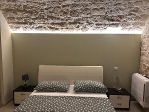 - une chambre avec un lit et 2 oreillers dans l'établissement Albergo Diffuso Dimora Rossi, à Turi