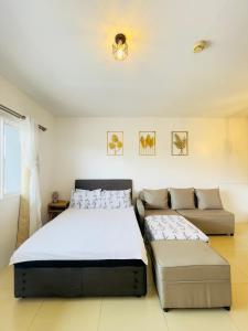 um quarto com 2 camas e um sofá em R Block Commercial Building em Naga