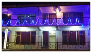 un edificio con una señal de neón azul en un balcón en OYO Holidayinn en Kargil
