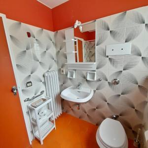 a bathroom with a white toilet and a sink at Hotel Maddalena in Marina di Ravenna