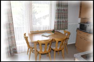 eine Küche mit einem Holztisch und 4 Stühlen in der Unterkunft Haus Barbara in Nauders