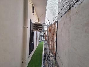 an empty hallway with green grass between two buildings at POP HOME 81260A Suneja Empire in Rohtak