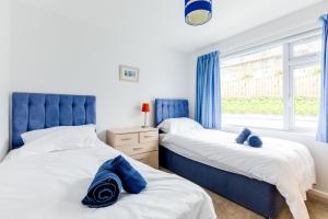two beds in a bedroom with a window at Chy-An-Var in Polzeath
