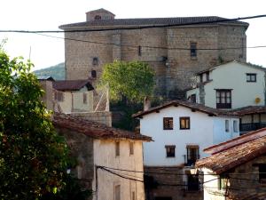 an old castle looms over the roofs of houses at Casasdetrevijano Cañon del rio leza in Soto en Cameros