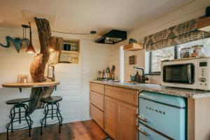 uma cozinha com um fogão e um micro-ondas em Ashley's Treehouse at El Mistico em Nogal