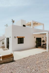 a white house with a roof at Casa De Surfos Cerritos’s Beach in San Carlos