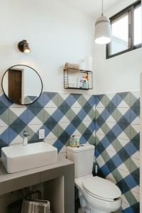 a bathroom with a toilet and a sink and a mirror at Casa De Surfos Cerritos’s Beach in San Carlos