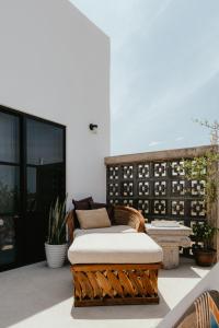 a rattan couch sitting on top of a patio at Casa De Surfos Cerritos’s Beach in San Carlos
