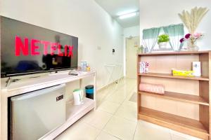 a living room with a television on a wall at Alanis Studio Suite  in Sepang