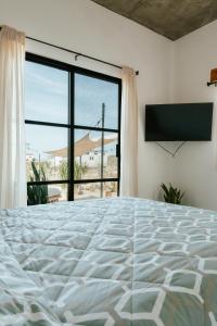 a bedroom with a large bed and a large window at Casa De Surfos Cerritos’s Beach in San Carlos
