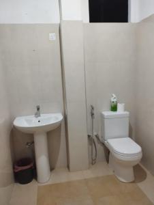 La salle de bains est pourvue de toilettes blanches et d'un lavabo. dans l'établissement Sunil's Homestay Sinharaja, à Kalawana