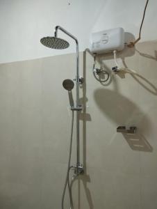 a shower in a bathroom with a light on the wall at Sunil's Homestay Sinharaja in Kalawana