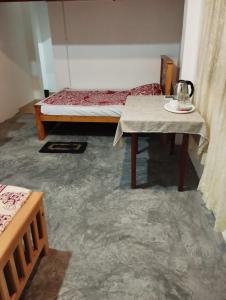 Kalawana的住宿－Sunil's Homestay Sinharaja，一间设有床铺和桌子的房间