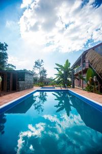 una piscina de agua azul frente a un edificio en Jungle Hut Resort Sigiriya, en Sigiriya