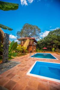 a resort with a swimming pool and a house at Jungle Hut Resort Sigiriya in Sigiriya