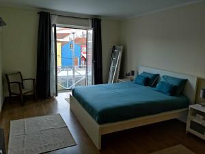a bedroom with a bed and a door to a balcony at Flamingo's House - Beautiful View Over the Canal in Aveiro