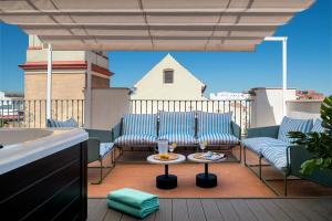 un patio con 2 sillas y una mesa en el balcón en Magno Apartments San Gil - Shared Jacuzzi en Sevilla