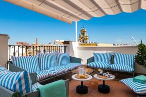 a patio with blue chairs and tables on a balcony at Magno Apartments San Gil - Shared Jacuzzi in Seville +39 photos