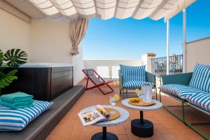 un patio con 2 sillas y una mesa en el balcón en Magno Apartments San Gil - Shared Jacuzzi en Sevilla
