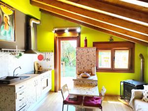 kuchnia z żółtymi ścianami, stołem i krzesłami w obiekcie Tranquila casita de invitados en Vigo con chimenea w mieście Vigo