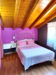 - une chambre rose avec un grand lit dans l'établissement Tranquila casita de invitados en Vigo con chimenea, à Vigo