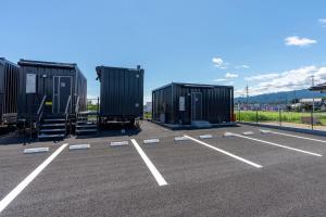 a parking lot with three large black containers at HOTEL R9 The Yard Tomioka in Tomioka