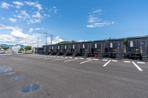 a row of black containers parked in a parking lot at HOTEL R9 The Yard Tomioka in Tomioka