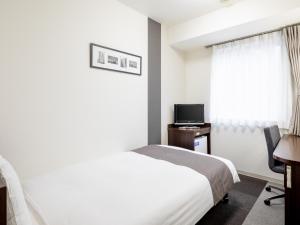 a bedroom with a bed and a desk and a television at Comfort Hotel Tokyo Kanda in Tokyo