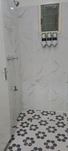 a bathroom with a shower and a black and white floor at ABM Court Apartments in Nadi +39 photos
