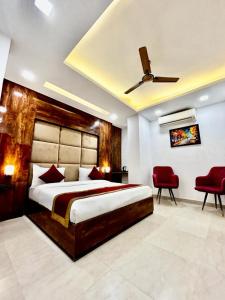 ein Schlafzimmer mit einem großen Bett und einem Deckenventilator in der Unterkunft Hotel Cosmo - Karol Bagh in Neu-Delhi