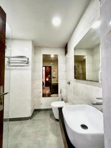 ein weißes Bad mit einem Waschbecken und einem WC in der Unterkunft Hotel Cosmo - Karol Bagh in Neu-Delhi