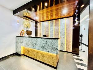 eine Lobby mit einer Marmortheke und einer gelben Bank in der Unterkunft Hotel Cosmo - Karol Bagh in Neu-Delhi