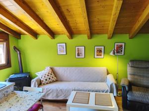 - un salon avec un canapé et un mur vert dans l'établissement Tranquila casita de invitados en Vigo con chimenea, à Vigo