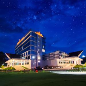 um edifício com um sinal em cima dele à noite em UNHAS HOTEL & CONVENTION em Patjinongong