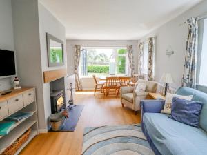 a living room with a blue couch and a table at Manor Cottage in Embleton