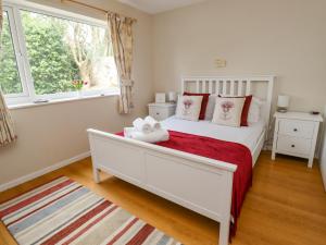 a bedroom with a white bed and a window at Manor Cottage in Embleton