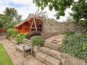 a garden with a bench in front of a house at Manor Cottage in Embleton