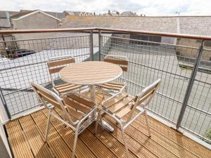 a table and chairs on a balcony with a table and chairs at Cuddy's Holm in Seahouses