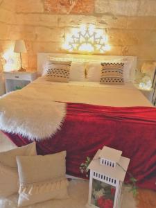 una camera da letto con un grande letto con coperta rossa e cuscini di Palazzo Emy a Lecce