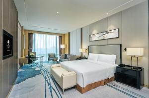 a hotel room with a bed and a living room at DoubleTree by Hilton Heyuan in Heyuan