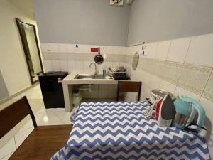 a small kitchen with a bed and a sink at KK City A2Z Api Api Studio Homestay in Kota Kinabalu +1 photo