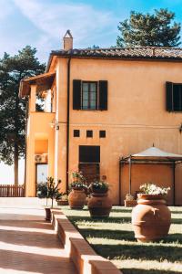 a house with large flower pots in front of it at Agriturismo Terra Di Dio Toscanizzazione in Capannoli