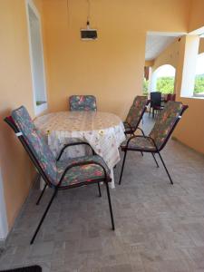 uma mesa com quatro cadeiras à volta numa sala em Apartman Malahov em Posedarje