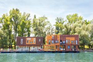 deux bâtiments sur l'eau à côté d'un lac dans l'établissement ArkaBarka Floating Hostel, à Belgrade