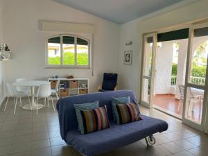 a living room with a blue couch and a table at Villa Titti Residence la Bussola in Fontane Bianche