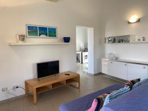 a living room with a couch and a tv and a table at Villa Titti Residence la Bussola in Fontane Bianche