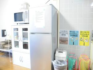 um frigorífico branco numa cozinha ao lado de um micro-ondas em Ueda Building - Vacation STAY 8563 em Asahikawa