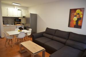 a living room with a couch and a table and a kitchen at Rita's house in Ponta Delgada
